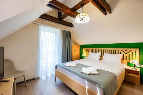 a bedroom with a large bed and a television at Villa Alpina Borsec in Borsec