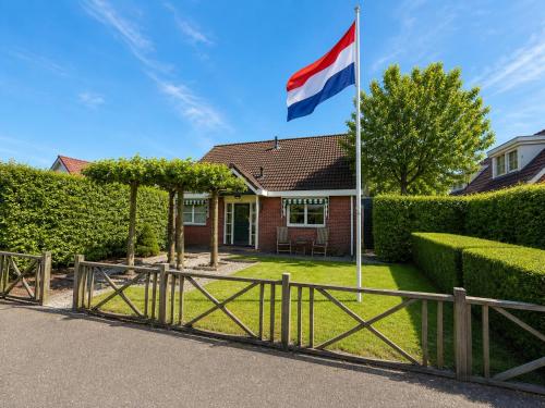 a british flag flying in front of a house at The Cosy Cottage - Comfort Sauna & Hot Tub in Private Garden in Zeewolde