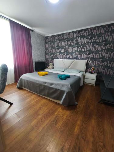 a bedroom with a large bed and a wall with at biker s home in Nabakhtevi