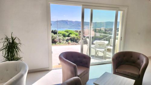 a room with two chairs and a table and a sliding glass door at Hotel with breakfast included in Palau in Proiettore