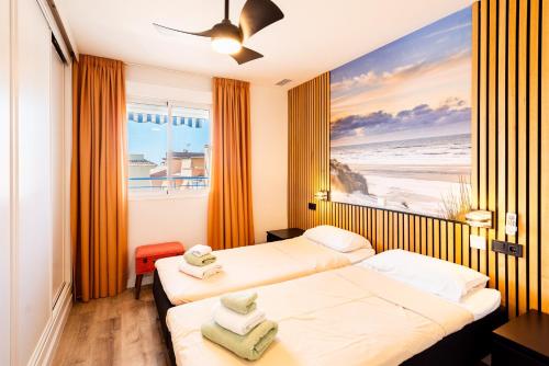 a hotel room with two beds and a painting of the beach at Breathtaking Penthouse Las Azaleas in Torrox
