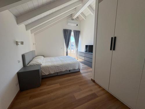 a bedroom with a bed and a large window at Mansarda Alla Palma in Intra