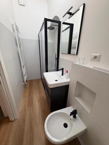 a bathroom with a white toilet and a sink at Mansarda Alla Palma in Intra
