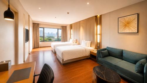 a hotel room with a bed and a couch at Pride Plaza Indore in Indore