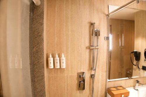 a bathroom with a shower and a sink and a mirror at Pride Plaza Indore in Indore
