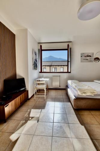 a bedroom with two beds and a television and a window at Bella Aqua Lake in Acquaseria