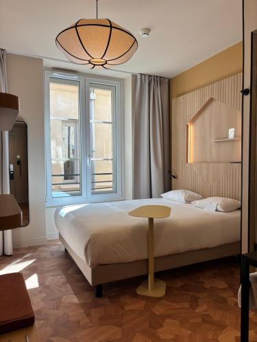 ein Schlafzimmer mit Bett, Tisch und Fenstern in der Unterkunft Best Western Lyon Saint-Antoine in Lyon