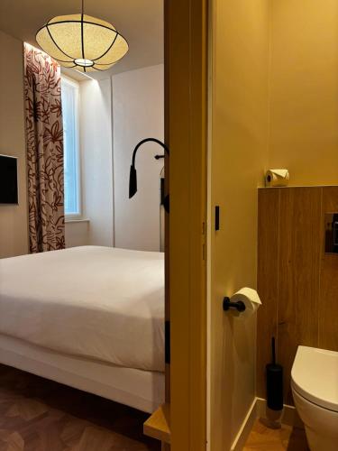 ein Schlafzimmer mit Bett und ein Badezimmer mit Toilette in der Unterkunft Best Western Lyon Saint-Antoine in Lyon