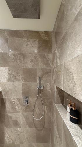 a bathroom with a shower with a shower head at Albazar Residence Salalah in Salalah