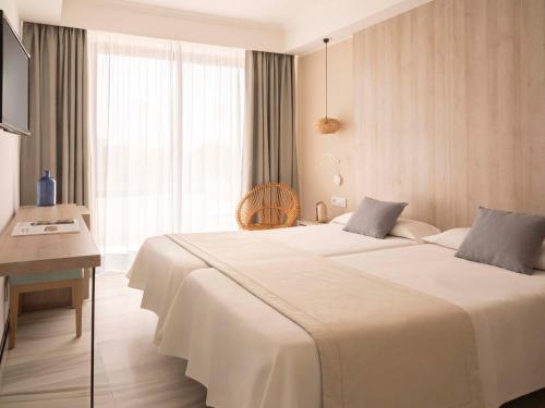 a hotel room with a large bed and a desk at Ona Palmira Paguera in Paguera