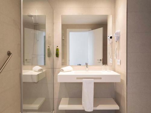 a bathroom with a sink and a mirror at Ona Palmira Paguera in Paguera