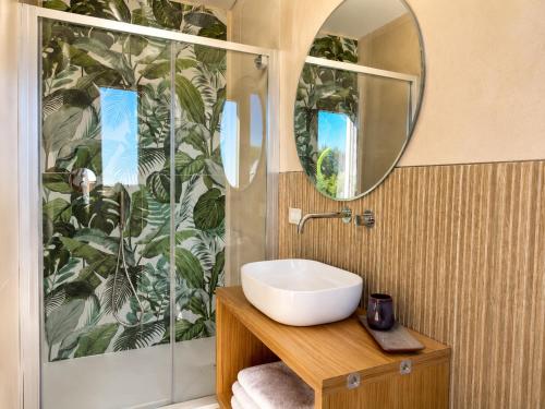 ein Badezimmer mit Waschbecken und Dusche mit Spiegel in der Unterkunft Corallo Home Resort in Le Castella