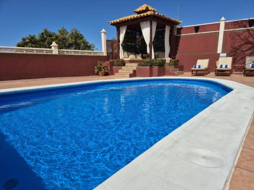 a swimming pool in front of a house with a gazebo at Villa Zen - Tu oasis en el sur de Tenerife in Adeje