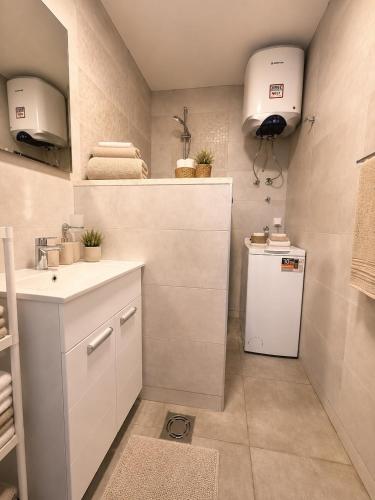 a small bathroom with a sink and a refrigerator at VN Lux Apartments in Prijevor