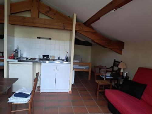 a kitchen and a living room with a couch and a table at L'auberge Chris and Chris in Retjons