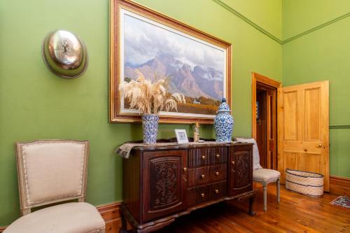 a room with a painting on the wall and a wooden cabinet at La Rochelle in Montagu