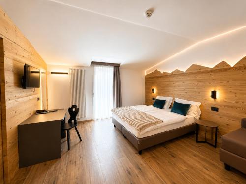 a hotel room with a bed and a desk at Hotel Kapriol in Folgarida