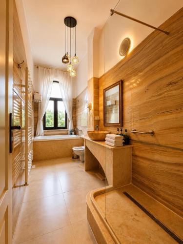 a bathroom with wooden walls and a tub and a sink at Queen's Crown Manor in Predeal