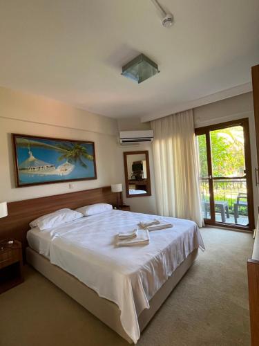 a bedroom with a large white bed and a window at Crescent Hasirci Hotel in Dalyan