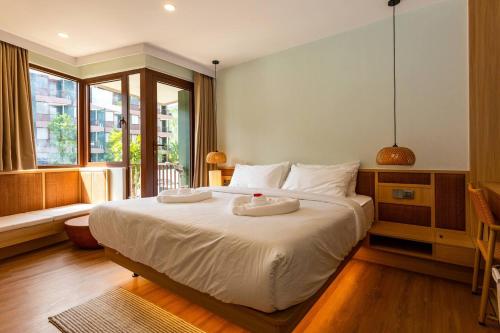 a bedroom with a large bed with two towels on it at Wing 4206 - Modern Resort Studio Koh Samui in Bophut
