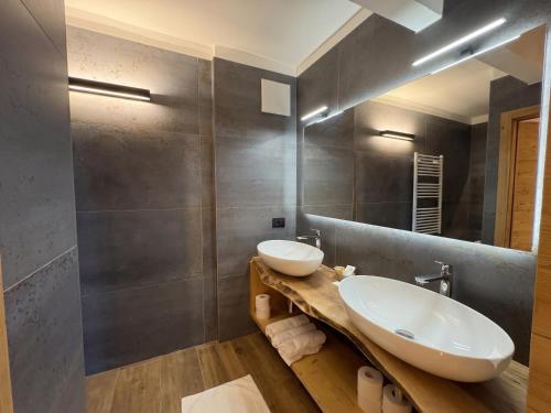 a bathroom with two sinks and a mirror at Hotel Kapriol in Folgarida