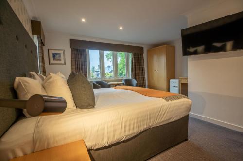 a bedroom with a large bed and a large window at The Murray Park Hotel in Crieff