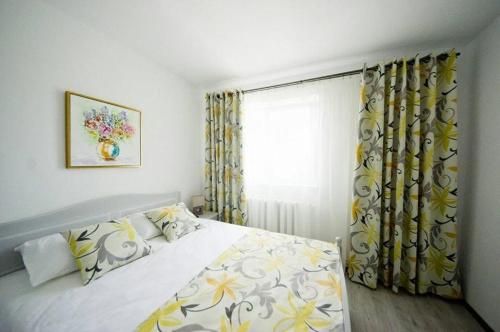a bedroom with a bed and a window with curtains at Boulevard residence in Alba Iulia