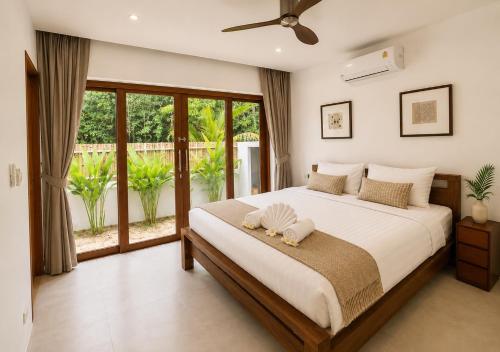 a bedroom with a bed and a large window at Tropical villa - Private pool - 3 bedrooms in Ko Phangan