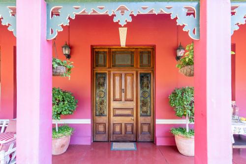 a pink house with a wooden door in front at La Rochelle in Montagu