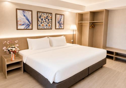a bedroom with a large white bed in a room at Miloft Suvarnabhumi Airport Hotel in Lat Krabang