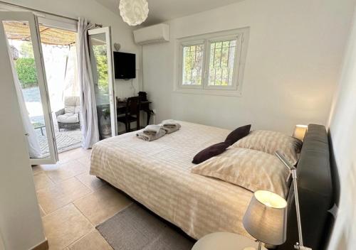 a bedroom with a bed and a sliding glass door at Villa Les Lucioles - Chambre indépendante - Piscine privative - Petit déjeuner - Parking in Valbonne