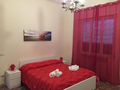 a bedroom with a red bed with towels on it at Diamante in Sorrento