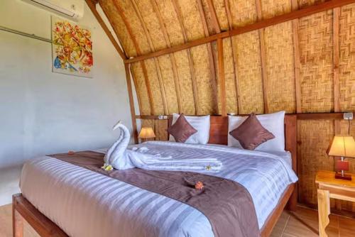 a bedroom with a bed with a swan on it at The Penida Angmas View in Nusa Penida