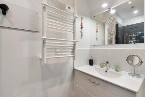 a white bathroom with a sink and a mirror at L'abri des Côtes - Veules les Roses in Pleine-sève