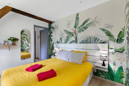 a bedroom with a yellow bed with red pillows at L'abri des Côtes - Veules les Roses in Pleine-sève
