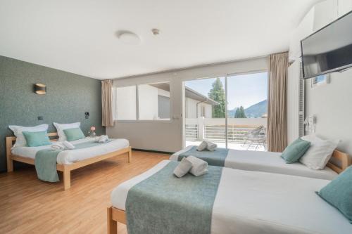 a bedroom with two beds and a large window at Centre Jean XXIII in Annecy