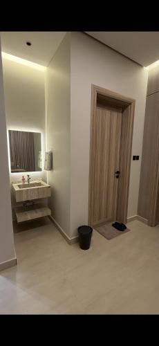 a bathroom with a sink and a mirror and a door at Elite Stay in Buraydah