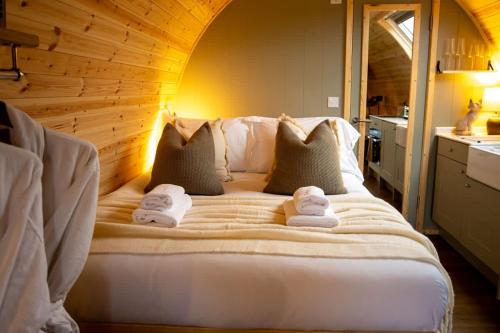 a bedroom with a large bed with towels on it at The Fox at Snowhill Glamping in Scorton