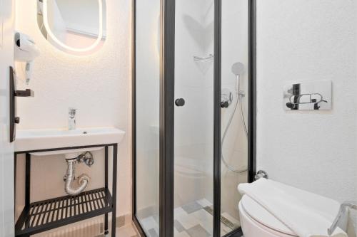 a bathroom with a shower and a toilet and a sink at Miralya Downtown in Fethiye