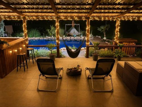 a patio with two chairs and a hammock on it at Wellness Glamping Apartmán Přerov in Přerov