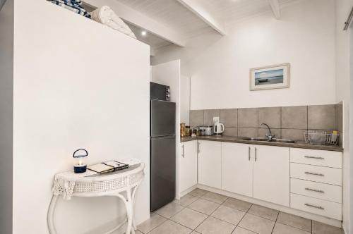 a kitchen with white cabinets and a black refrigerator at Jacobsdaller #1 in Jacobs Bay