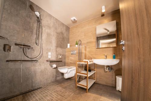 ein Badezimmer mit Waschbecken, Toilette und Dusche in der Unterkunft Lignum Hotel in Miskolctapolca