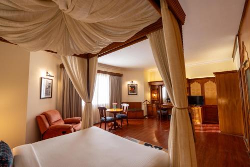 a bedroom with a canopy bed and a living room at KK Royal Hotel & Convention Centre in Jaipur