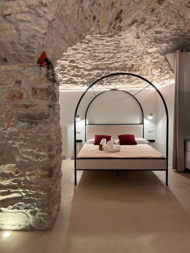 a bedroom with a bed in a stone wall at AmarVite con spa privata in Dolceacqua