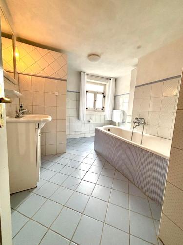 a large bathroom with a tub and a sink at Weiherhof in Ehrenberg