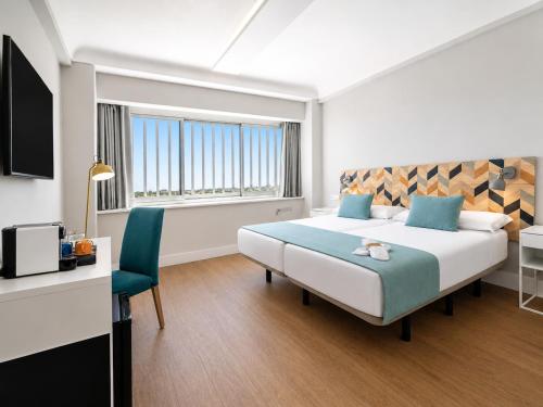 ein Schlafzimmer mit einem großen Bett, einem Schreibtisch und einem Stuhl in der Unterkunft Hotel Chamartin The One in Madrid
