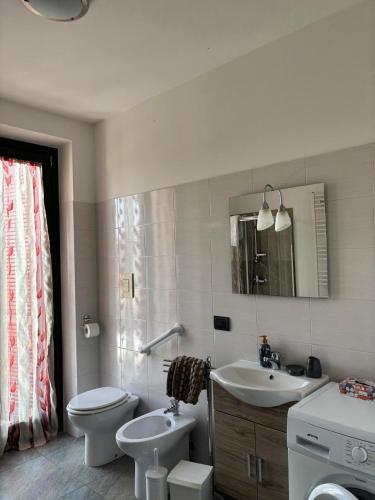 a bathroom with a toilet and a sink and a mirror at Ca Sofia in Cervere
