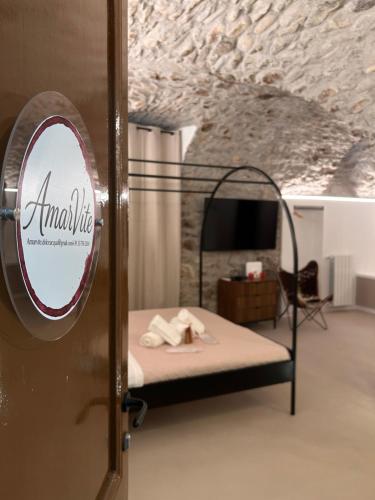a room with a bed with a sign on the door at AmarVite con spa privata in Dolceacqua