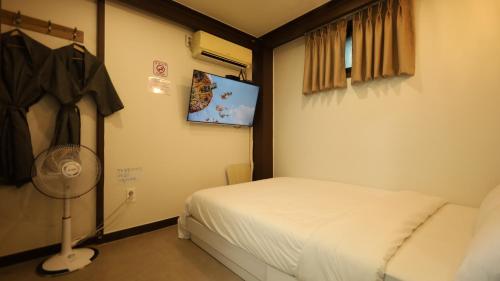 ein kleines Schlafzimmer mit Bett und Ventilator in der Unterkunft Dal Hotel in Seoul