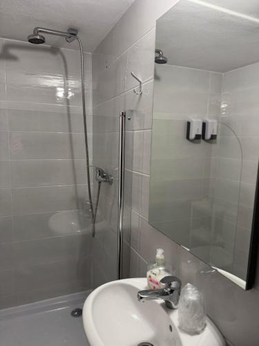 a bathroom with a sink and a glass shower at Casa do Ribeirinho in Amarante